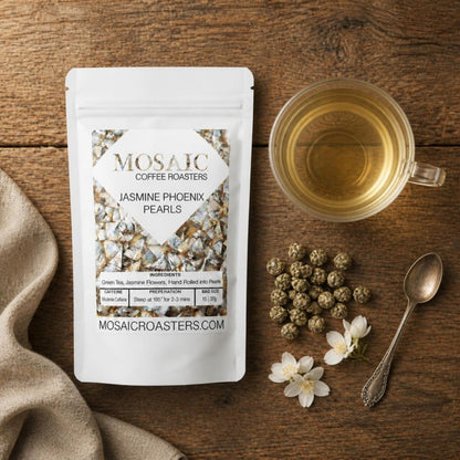 Jasmine Phoenix Pearls tea pouch flat lay with hand-rolled tea pearls and a cup of jasmine green tea