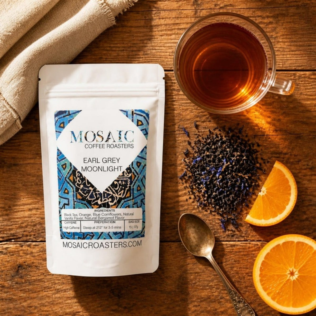 Earl Grey Moonlight tea pouch flat lay with loose tea, cornflowers and orange