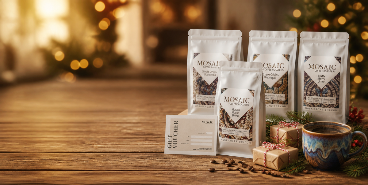 Mosaic Coffee Roasters coffee bags, gift card and wrapped gifts on a holiday table